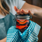 woman holding a glass with fermented vegetables